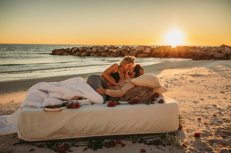 Wedding & Elopement Photographer, man and woman lying on a bed by the ocean